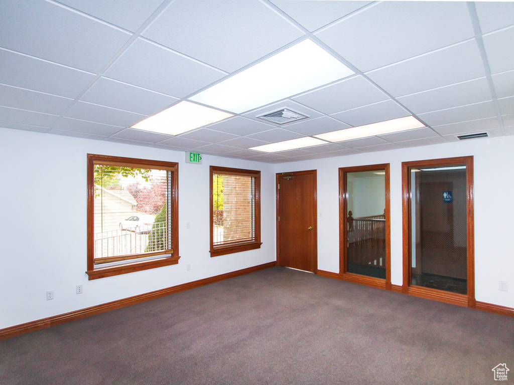 Carpeted empty room featuring a paneled ceiling