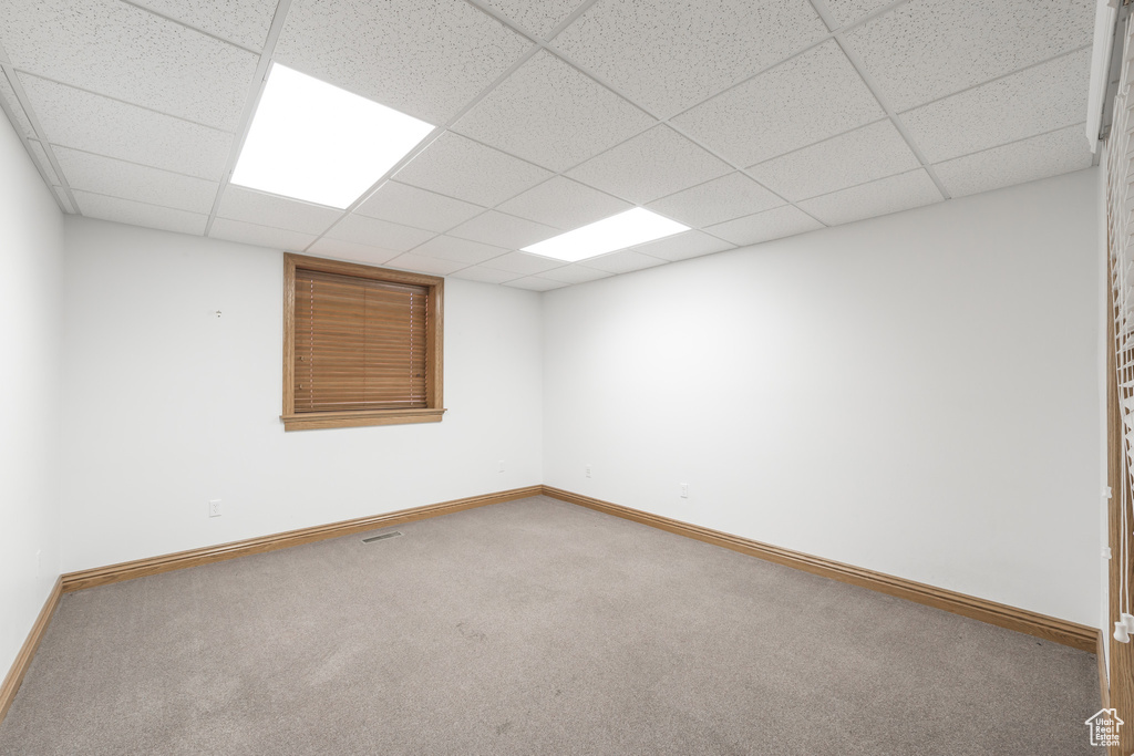 Unfurnished room with a paneled ceiling and carpet floors