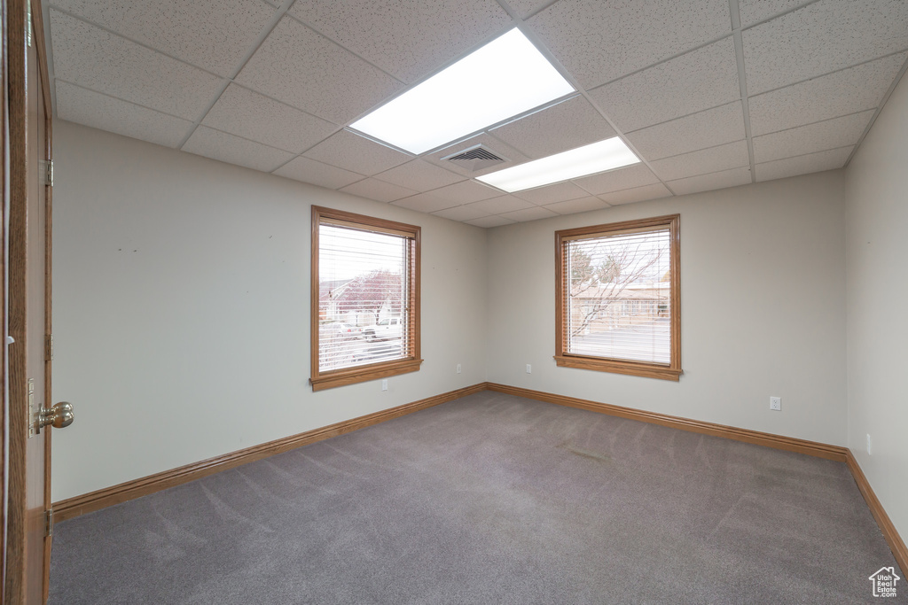 Unfurnished room with a drop ceiling and carpet flooring