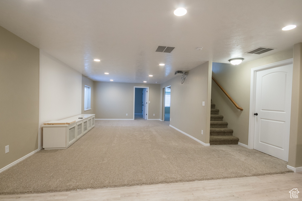 Basement featuring a healthy amount of sunlight and light colored carpet