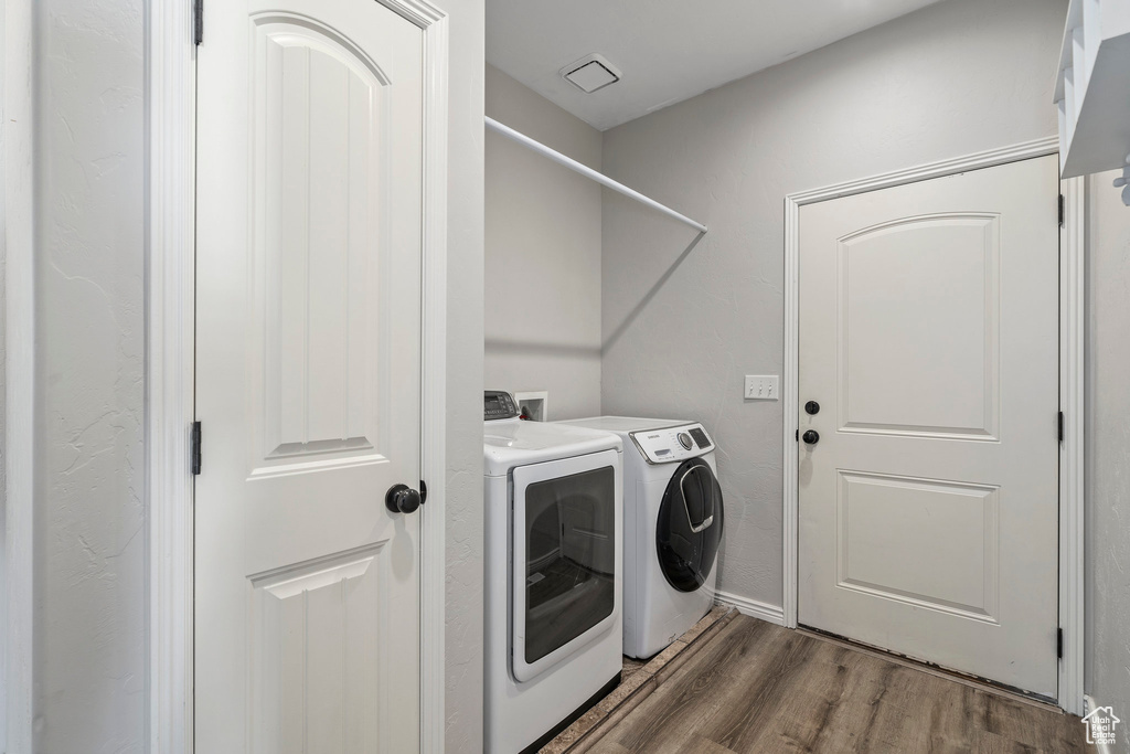Laundry area featuring dark hardwood / wood-style floors, washing machine and dryer, and hookup for a washing machine