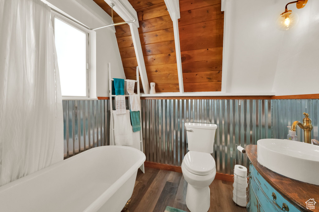 Bathroom with wood walls, hardwood / wood-style floors, vanity, and toilet
