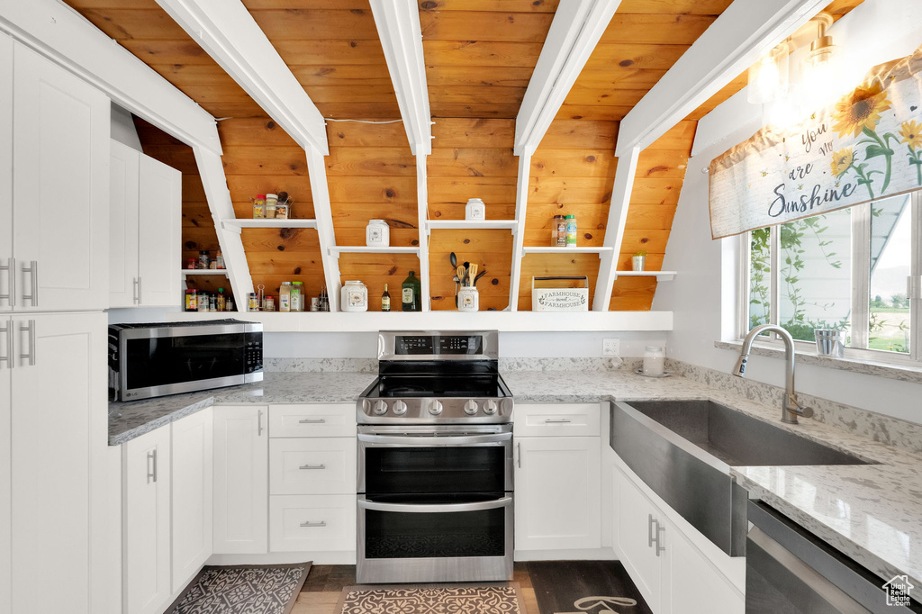 Kitchen featuring appliances with stainless steel finishes, white cabinets, dark hardwood / wood-style floors, and wooden ceiling