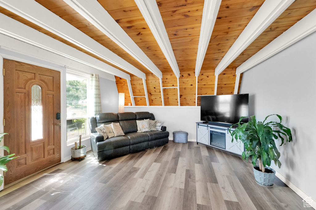 Living room with light hardwood / wood-style flooring, beam ceiling, and wood ceiling