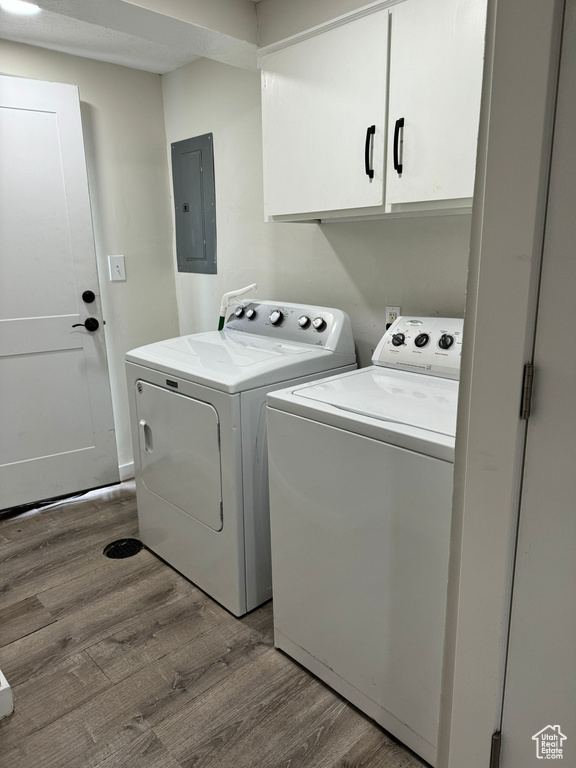 Laundry area featuring cabinets, washer and dryer, and hardwood / wood-style flooring