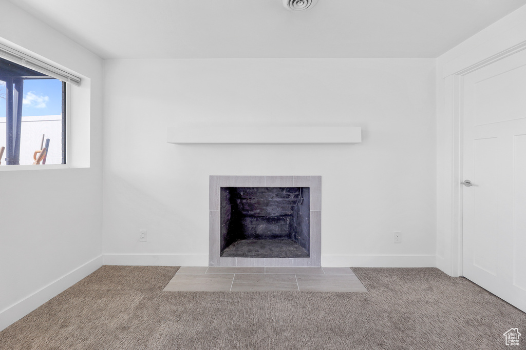 Room details featuring light colored carpet and a fireplace