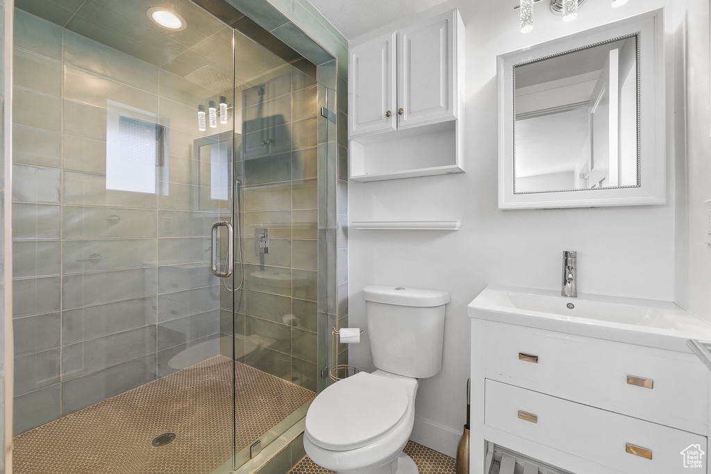 Bathroom featuring walk in shower, large vanity, and toilet