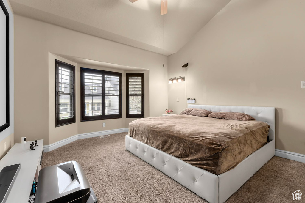 Bedroom with high vaulted ceiling, ceiling fan, and light carpet