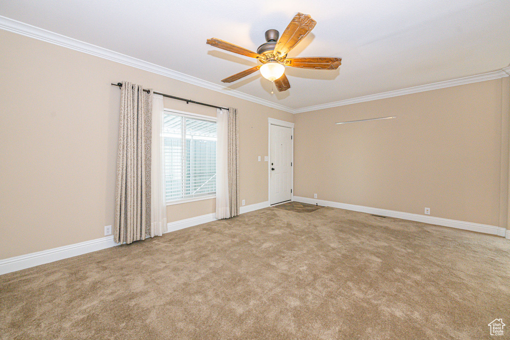 Carpeted spare room with ornamental molding and ceiling fan
