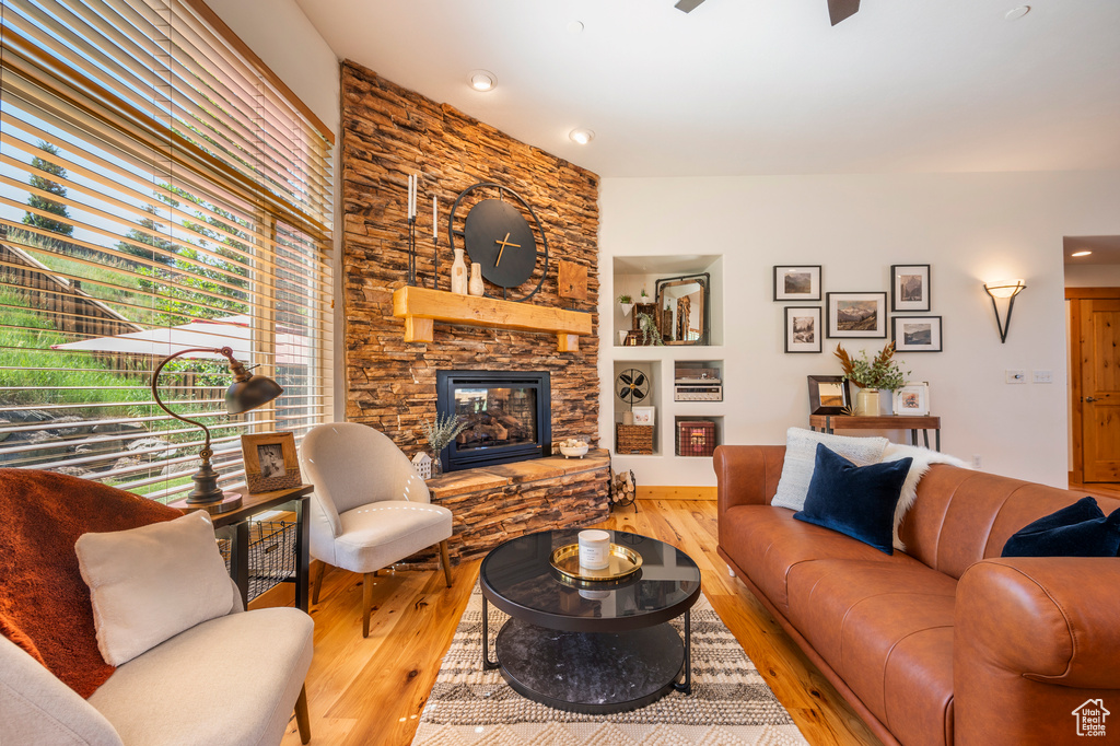 Living room featuring light hardwood / wood-style floors and a stone fireplace