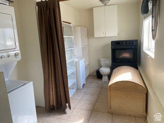 Interior space with stacked washer and dryer and light tile flooring