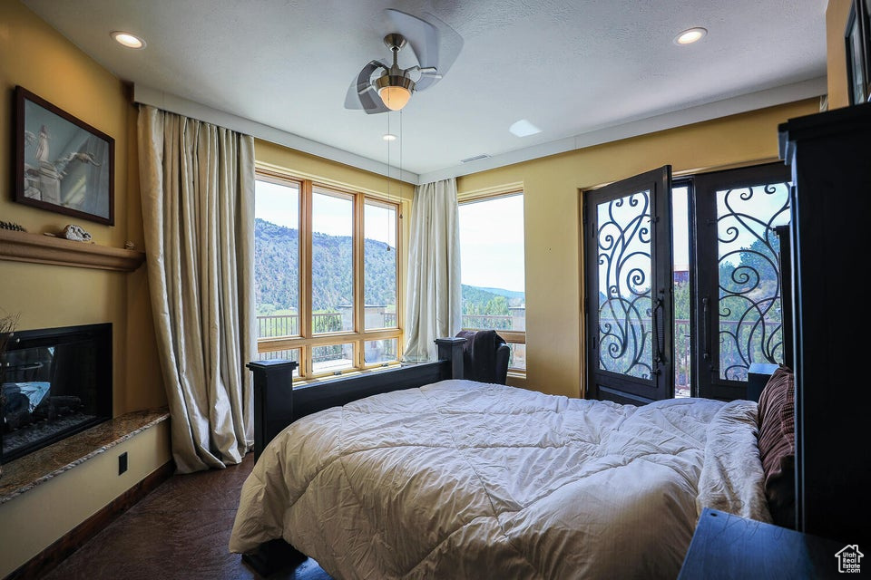 Carpeted bedroom with a mountain view and ceiling fan