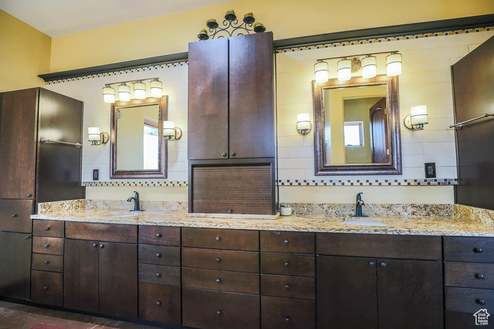 Bathroom with double sink vanity and tile walls