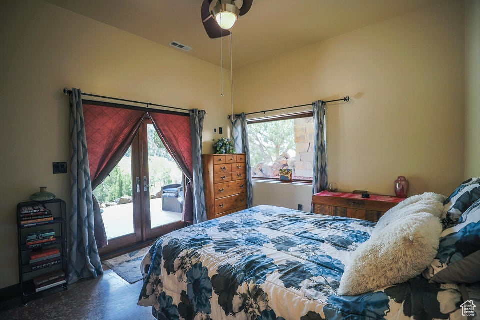 Bedroom featuring french doors, multiple windows, ceiling fan, and access to exterior