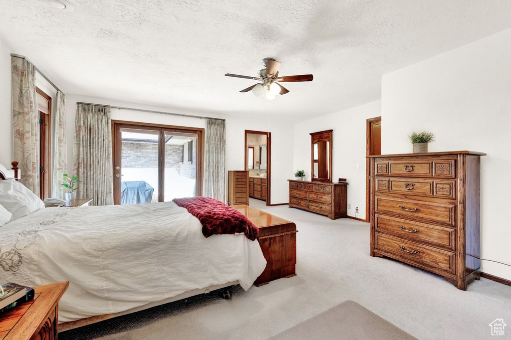 Carpeted bedroom with a textured ceiling, ceiling fan, and access to outside