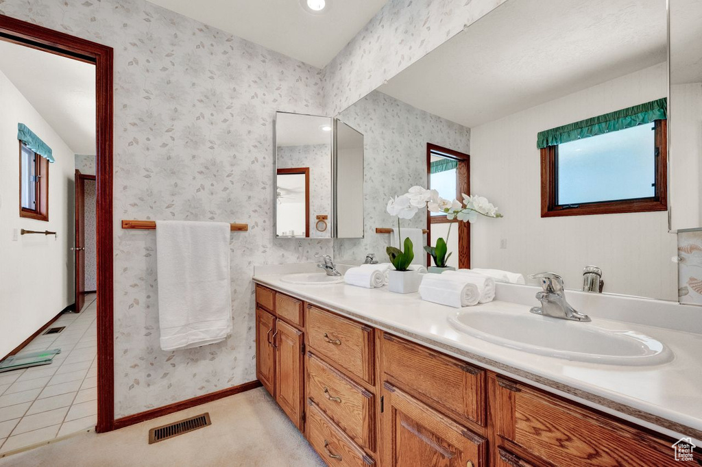 Bathroom featuring dual bowl vanity and tile flooring