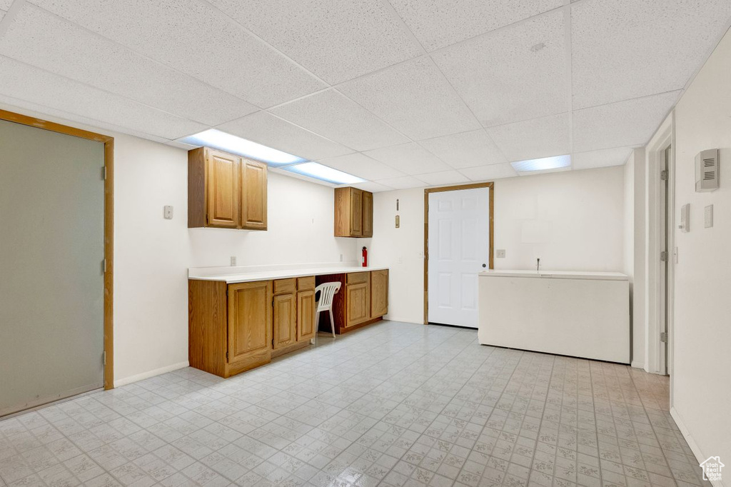 Kitchen with a drop ceiling and light tile floors