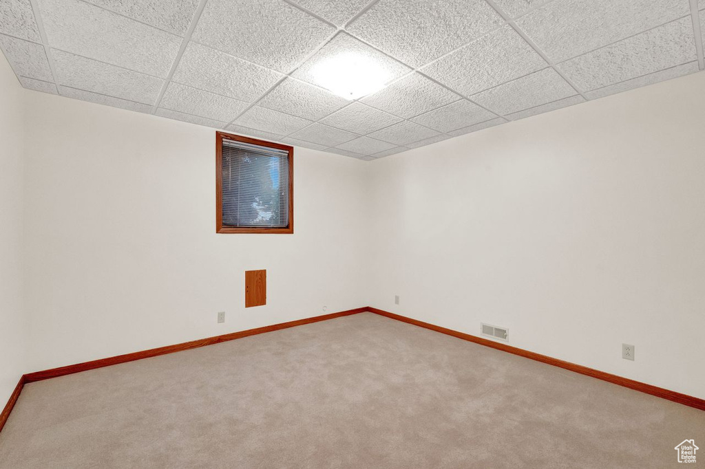 Spare room featuring carpet and a paneled ceiling