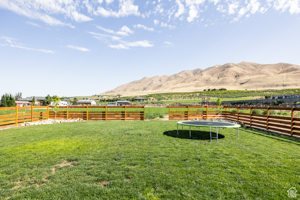 View of yard featuring a trampoline, a mountain view, and a rural view