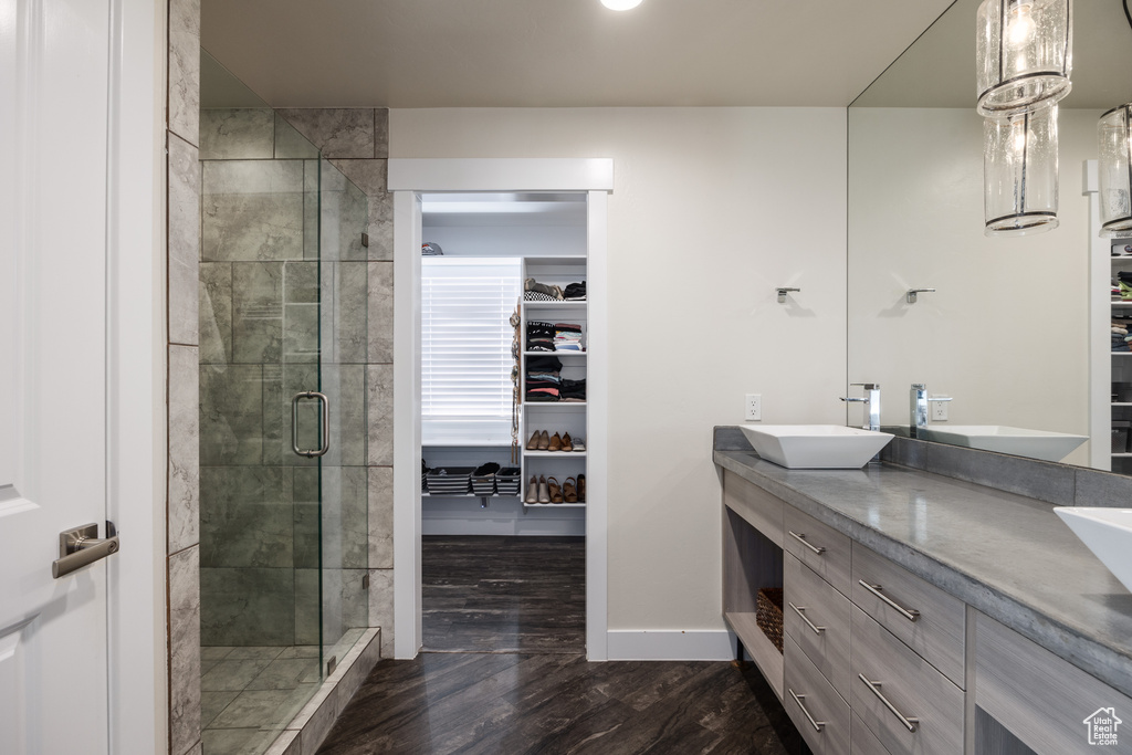 Bathroom featuring hardwood / wood-style flooring, a shower with door, and vanity