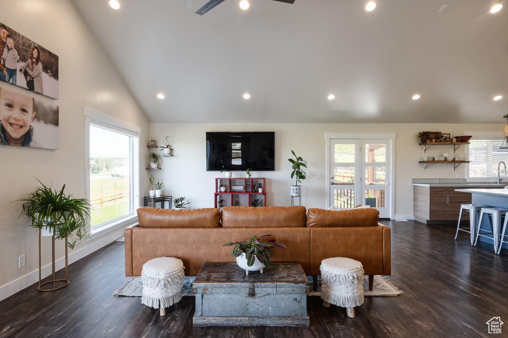 Living room featuring high vaulted ceiling, dark wood-type flooring, and ceiling fan