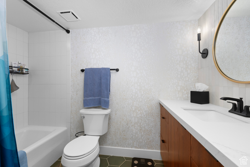 Full bathroom featuring shower / bath combo with shower curtain, tile walls, large vanity, tile flooring, and toilet