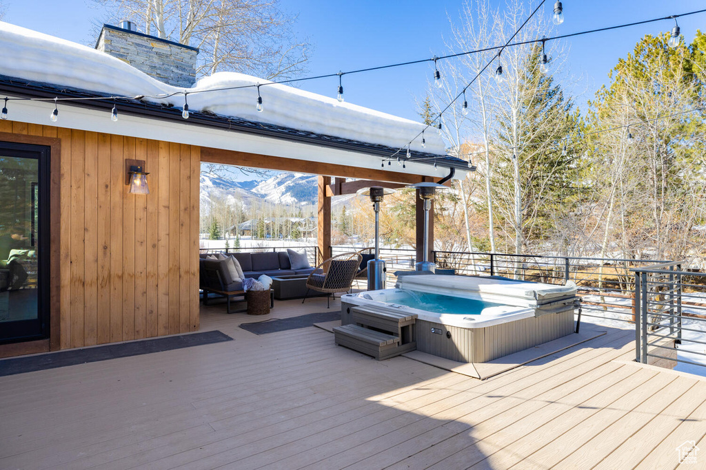 Wooden terrace featuring a mountain view and a covered hot tub