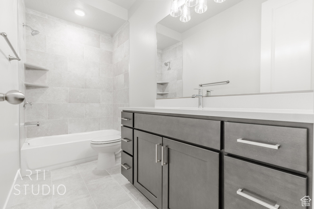 Full bathroom with vanity, toilet, tiled shower / bath combo, and tile patterned flooring