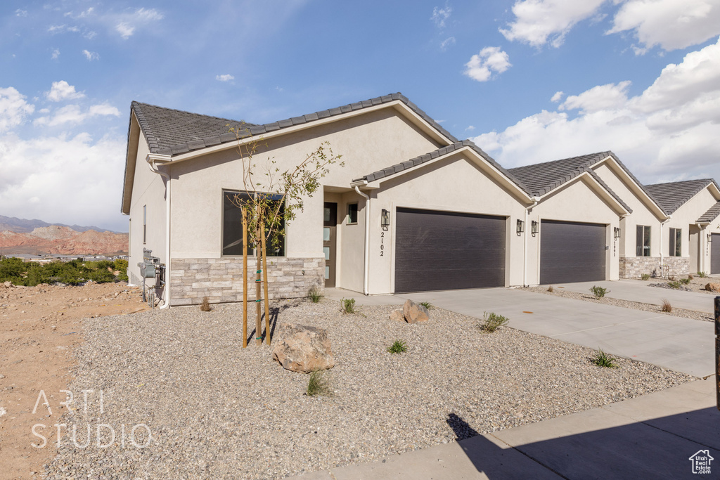 View of front of house with a mountain view and a garage