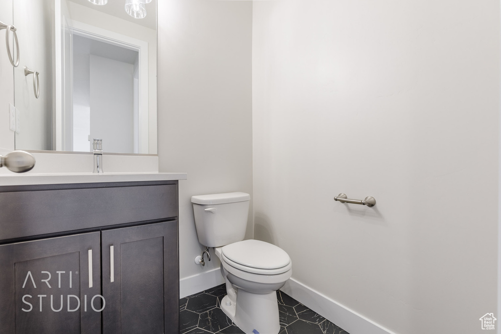 Bathroom featuring vanity, toilet, and tile patterned floors