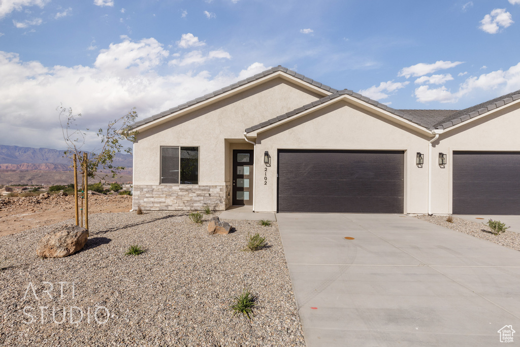 View of front of house featuring a mountain view and a garage