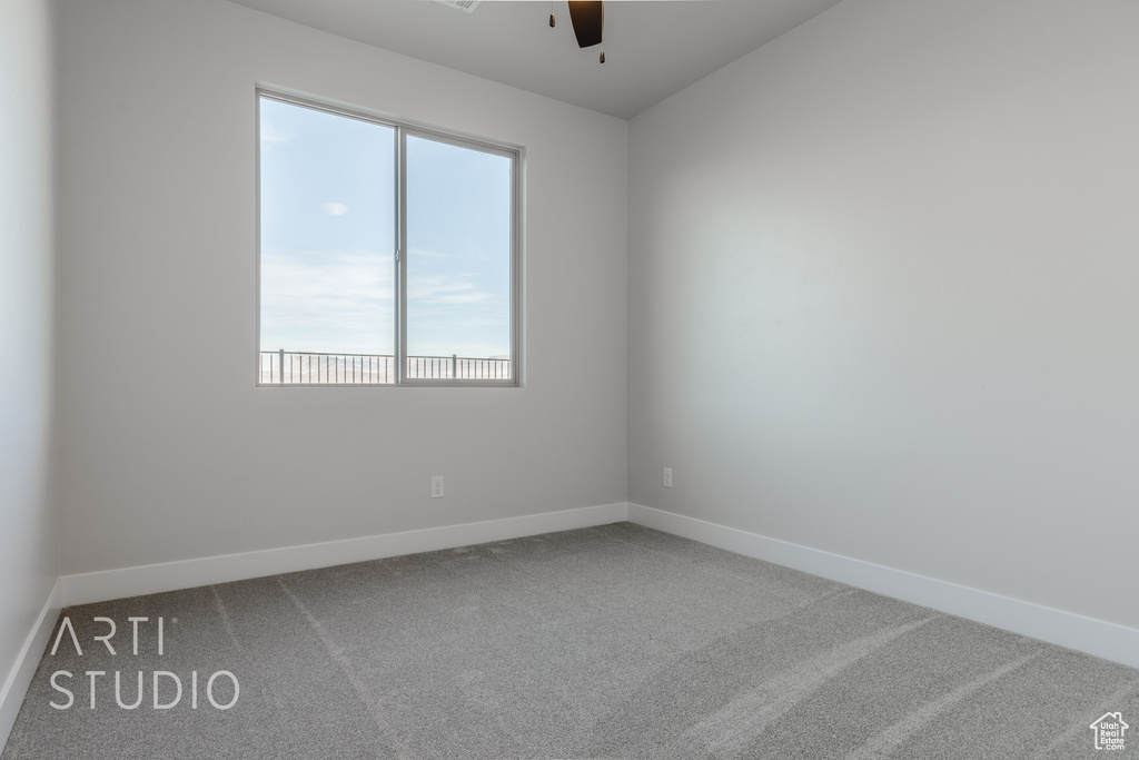 Carpeted empty room featuring ceiling fan