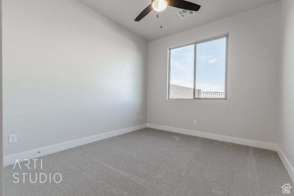 Empty room featuring ceiling fan and carpet