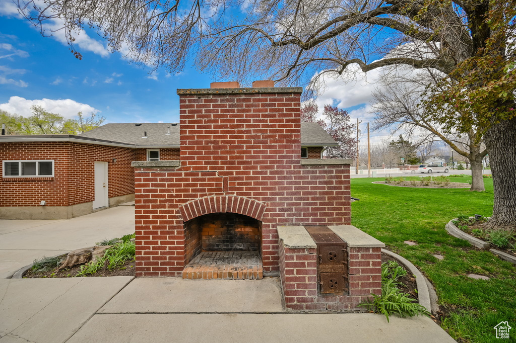 Exterior space with a lawn and an outdoor brick fireplace