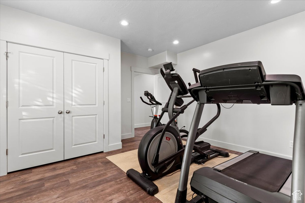 Workout room with dark hardwood / wood-style flooring