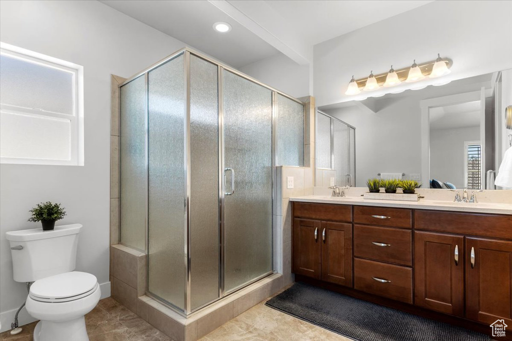 Bathroom featuring walk in shower, double sink, oversized vanity, tile flooring, and toilet