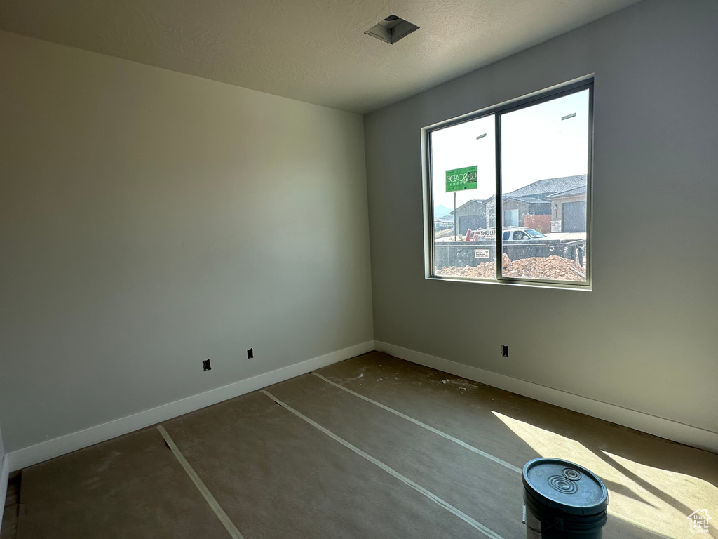 Unfurnished room featuring concrete flooring and a textured ceiling