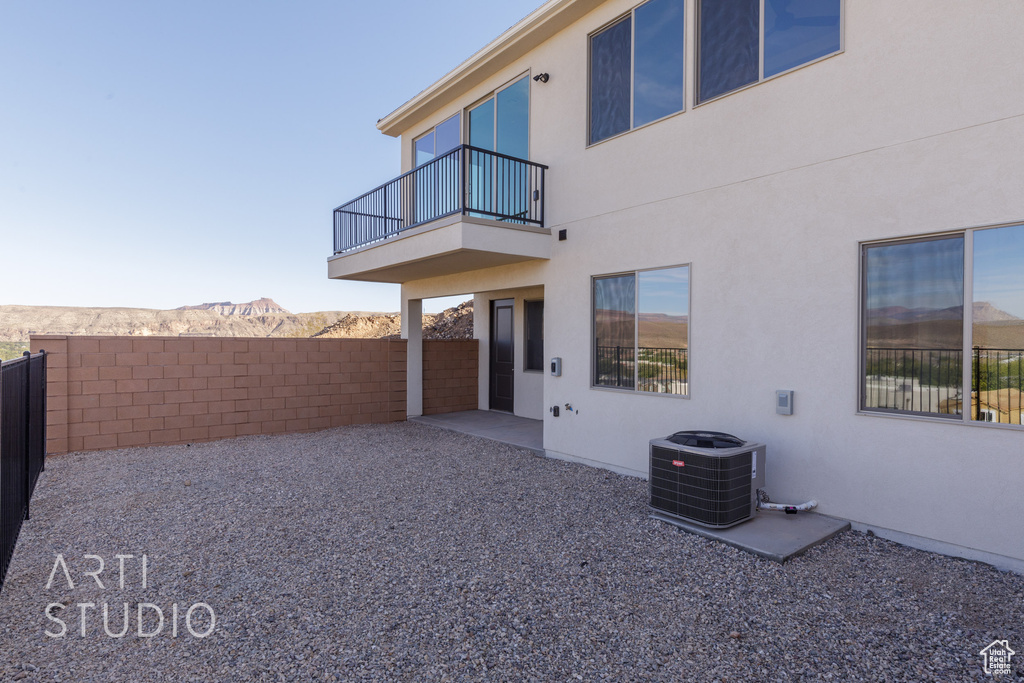 Back of house featuring a balcony, a mountain view, a patio area, and central AC unit