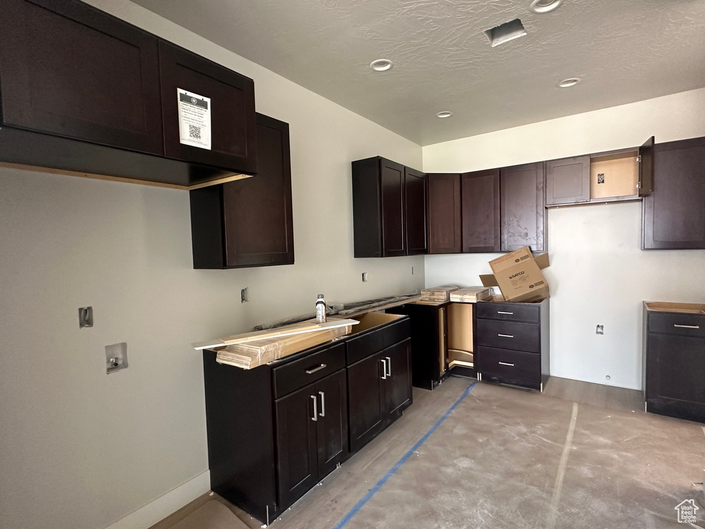 Kitchen with dark brown cabinetry and a textured ceiling