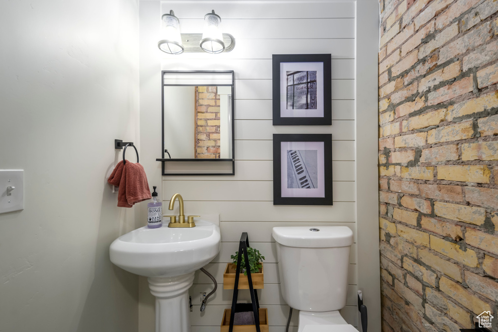 Bathroom with brick wall and toilet