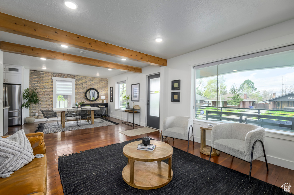 Living room featuring hardwood / wood-style floors, beamed ceiling, and plenty of natural light