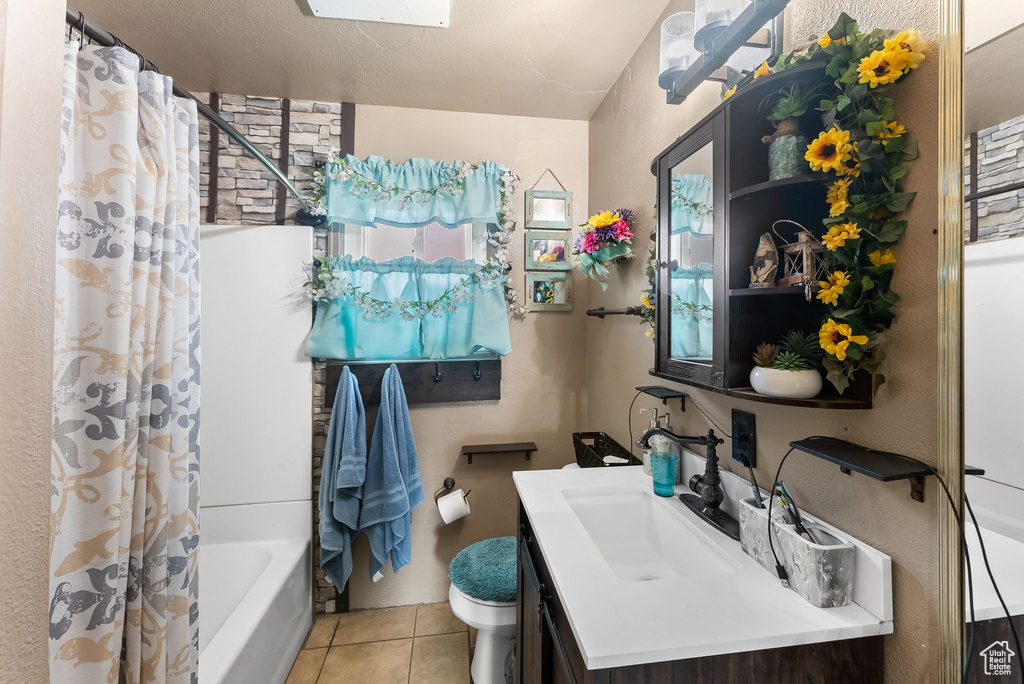 Full bathroom with toilet, tile floors, shower / bath combination with curtain, and large vanity