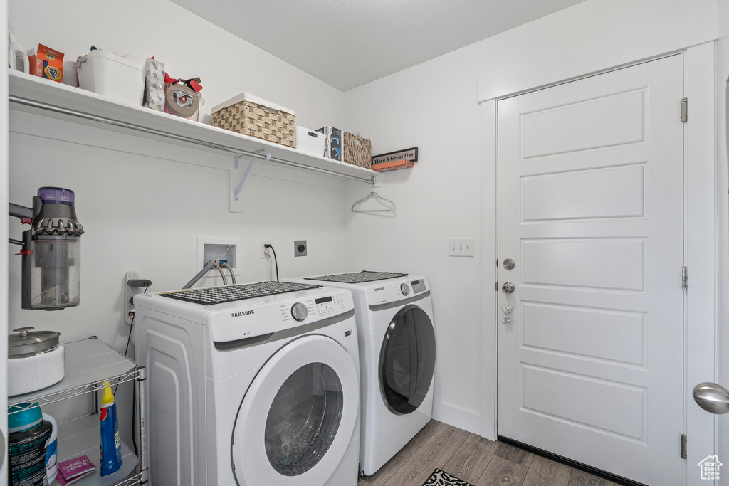 Laundry area featuring hookup for a washing machine, separate washer and dryer, hookup for an electric dryer, and hardwood / wood-style flooring