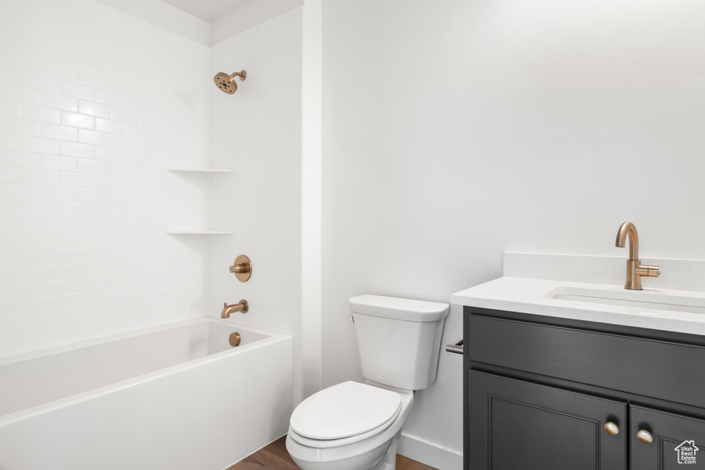 Full bathroom featuring wood-type flooring, shower / bathing tub combination, vanity, and toilet