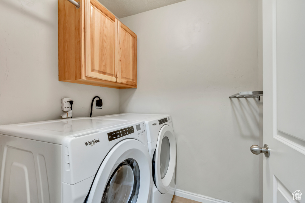 Laundry area featuring washer and clothes dryer, hookup for an electric dryer, and cabinets
