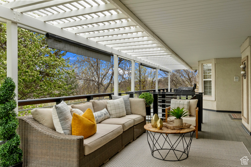 Wooden balcony with outdoor lounge area, a wooden deck, and a pergola