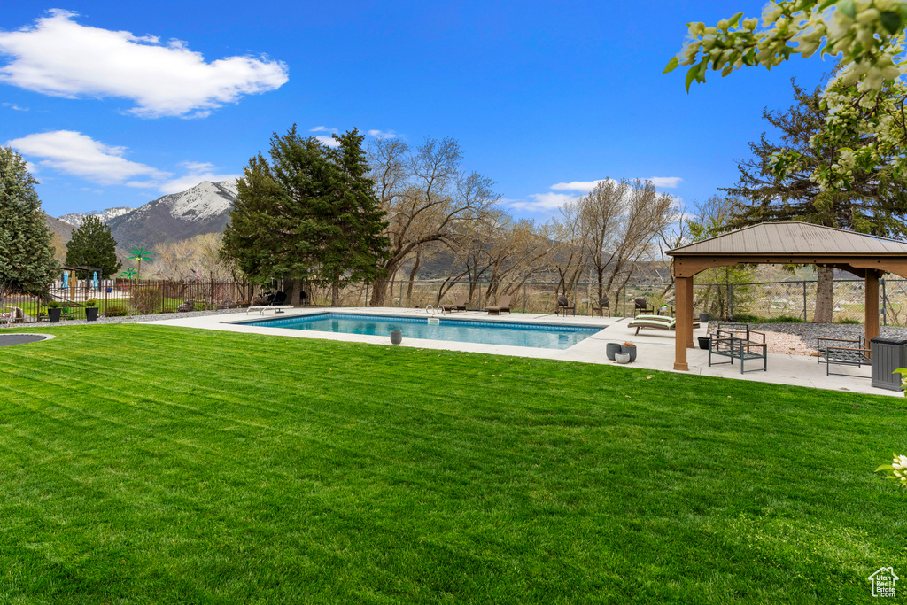 View of pool featuring a gazebo, a mountain view, a patio, and a lawn