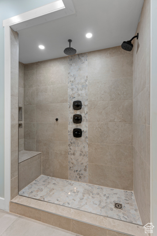 Bathroom featuring tiled shower and tile floors