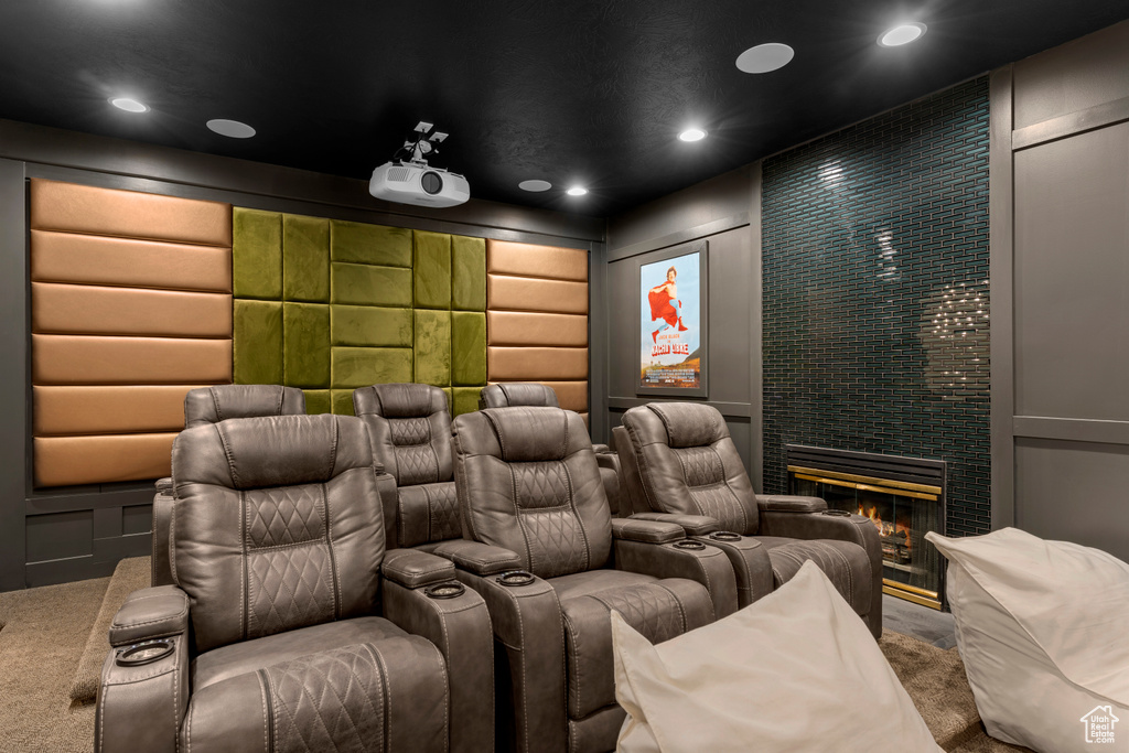 Carpeted cinema room with a brick fireplace