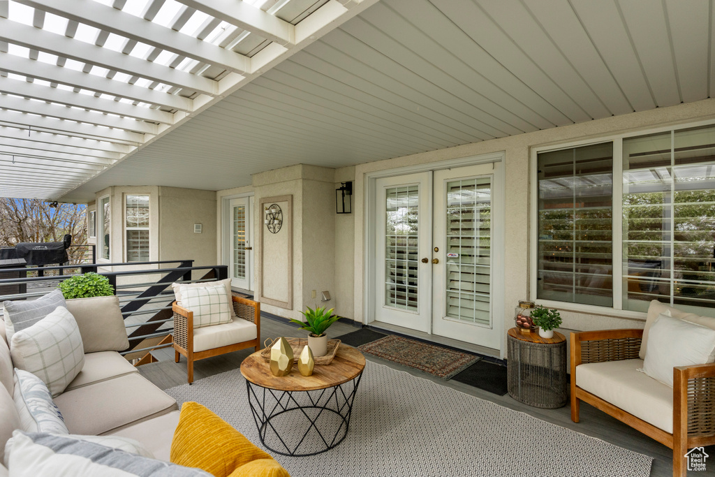View of terrace featuring french doors, an outdoor living space, and a pergola